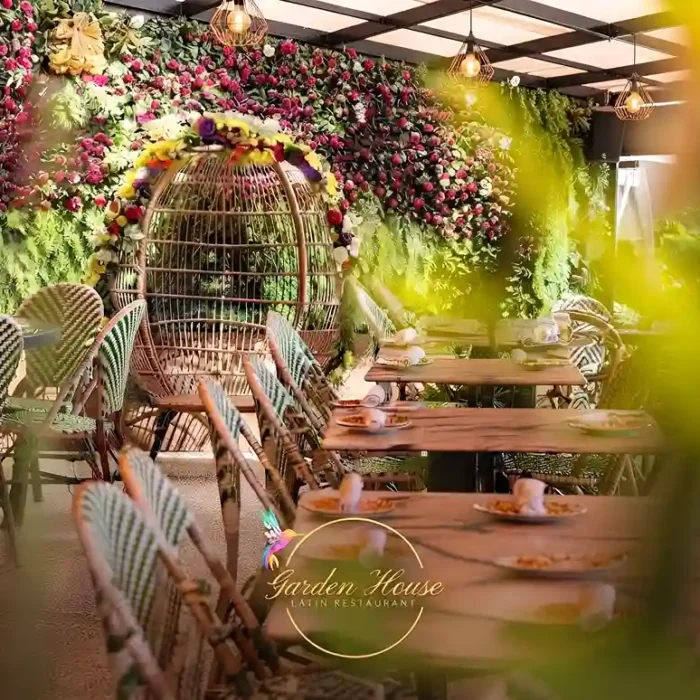 Entrada y terraza ajardinada del restaurante de comida colombiana