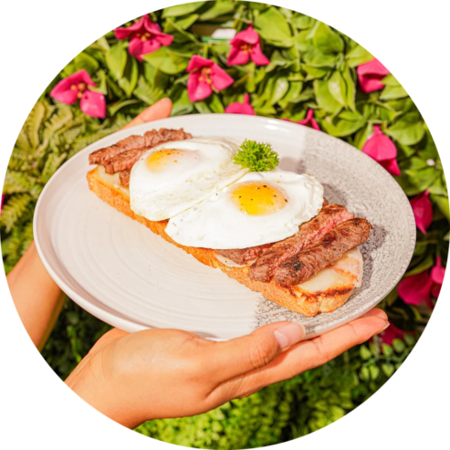 Colombian Brunch Special Colombian brunch dish with fried eggs bacon and fresh salad garnish