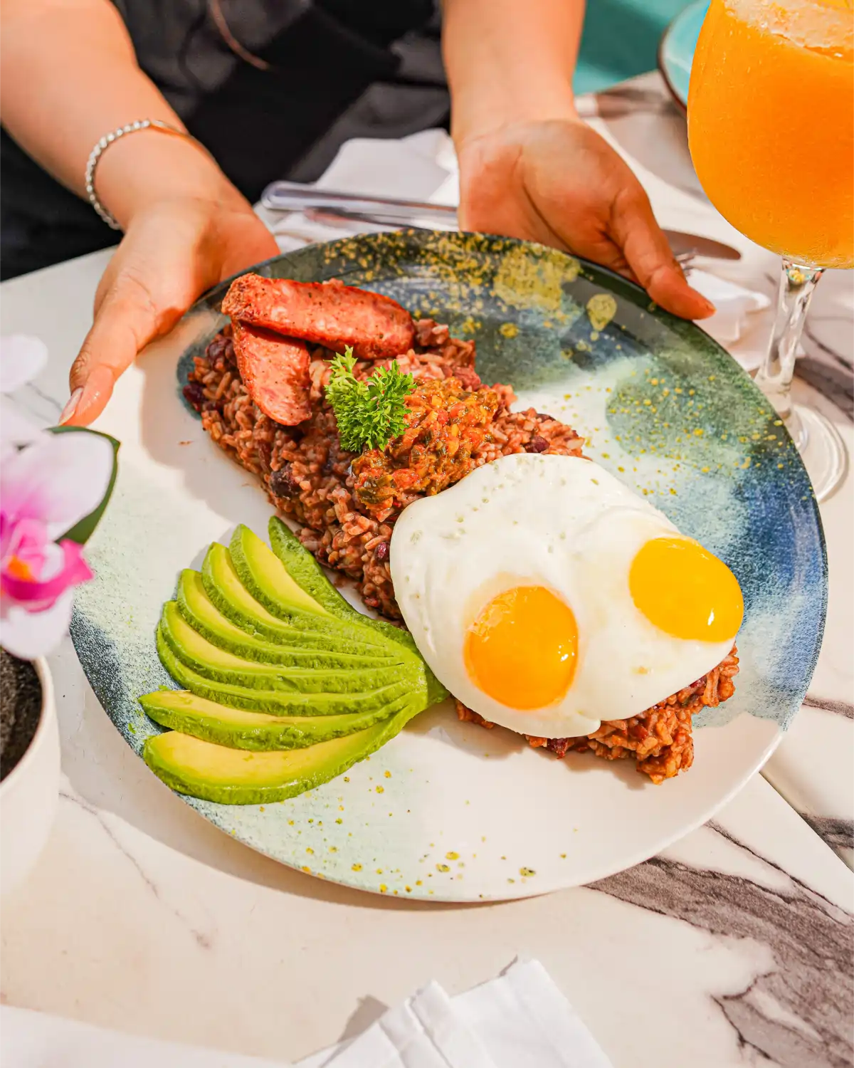 Traditional Colombian breakfast with fried eggs, sliced avocado, and grilled steak at Garden House Restaurant